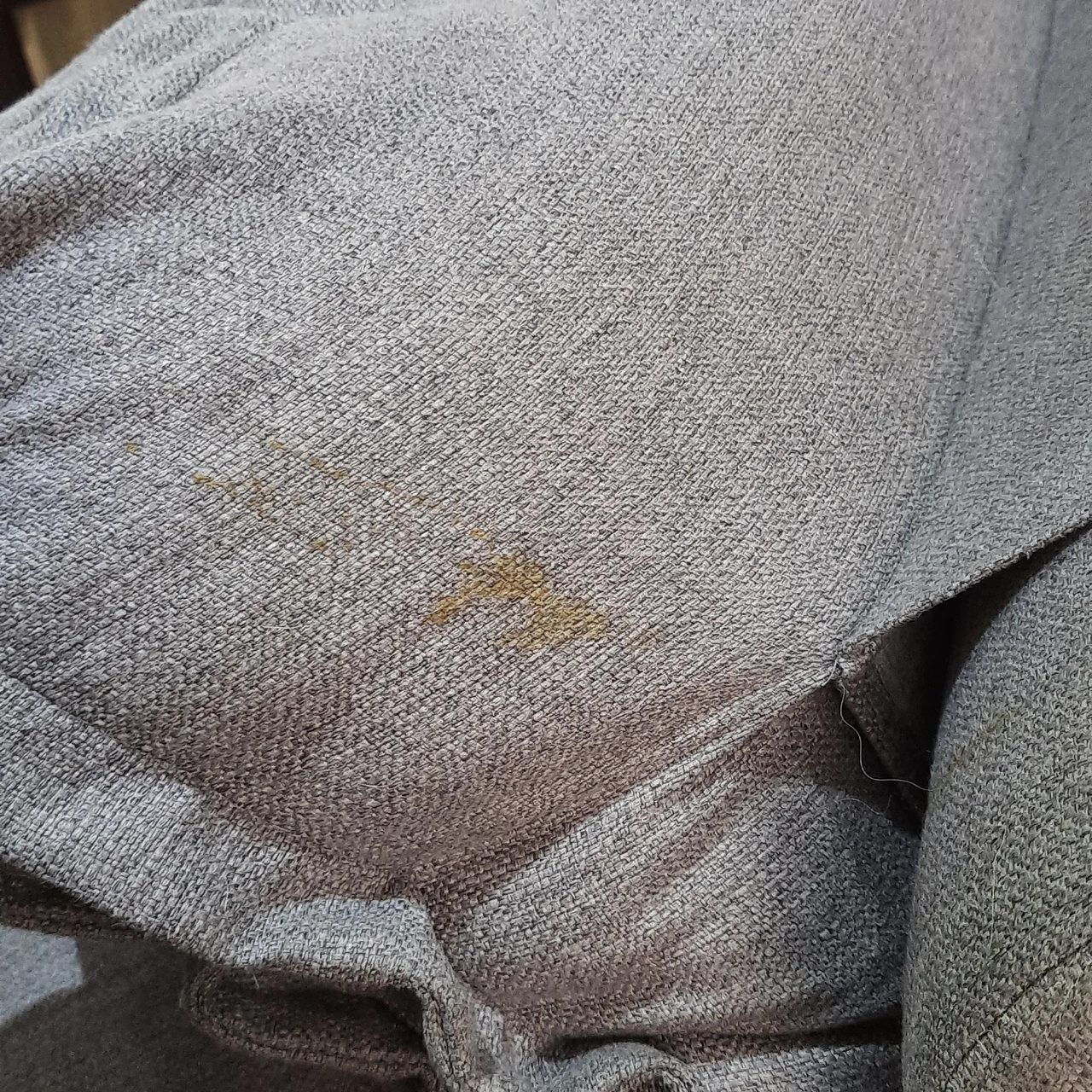 Sofá de chenille cinza com mancha amarelada antes da higienização