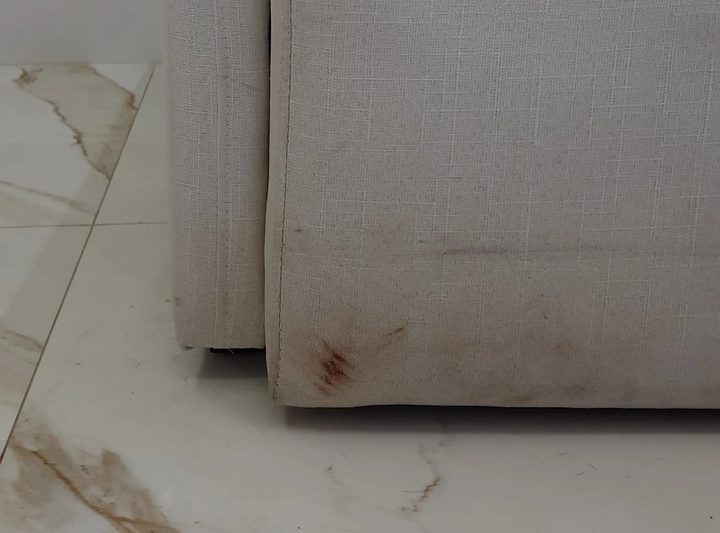 Detalhe de mancha em estofado claro antes do tratamento